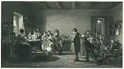 An older woman sits at a table in a disorganised classroom. She is surrounded by children; many of whom appear bored or are playing.