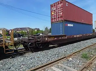 A 53-foot well car also fitted with a fifth-wheel coupling to allow semi-trailer transport as well