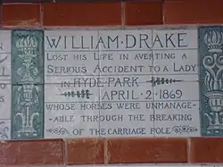 A tablet formed of six standard sized tiles, bordered by green flowers in the style of the Arts and Crafts movement