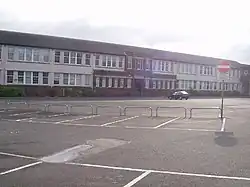 Partial view of two-storey school building and its main entrance