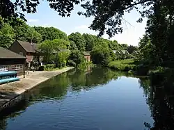 Photograph of buildings with a concrete apron beside a river