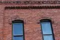 Brick corbelling and dentillation above two windows