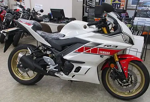 A white and red sports motorcycle facing to the right in a dealership
