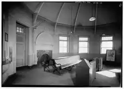 A railway station waiting room with a curved wall and a fireplace